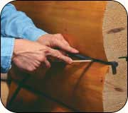 Install backer rod into the caulk well of clean, stained logs.